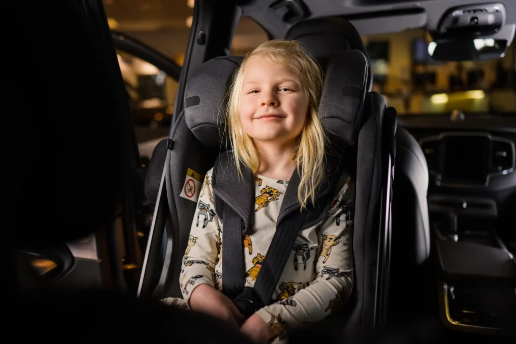 a girl in axkid rear facing car seat